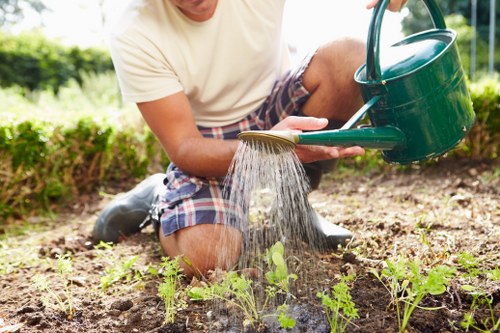 Gardener performing regular garden maintenance in a small urban garden